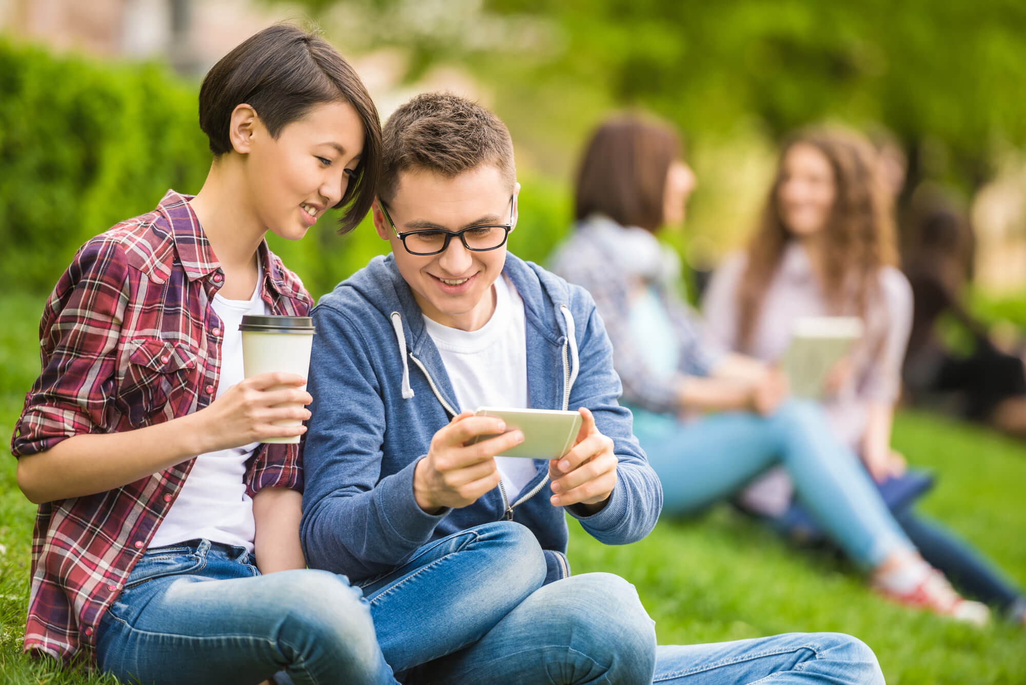 students sitting on grass talking