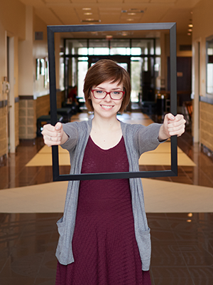 student holding picture frame